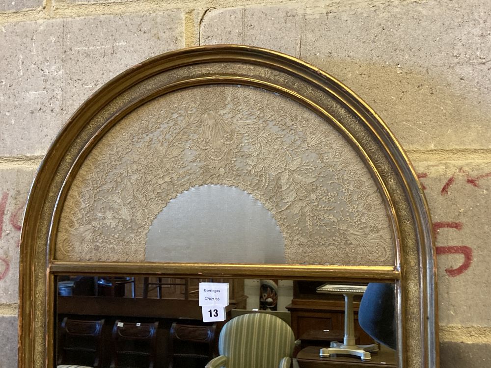 A modern gilt framed wall mirror, the arched top with an inset lacework panel, width 59cm, height 112cm